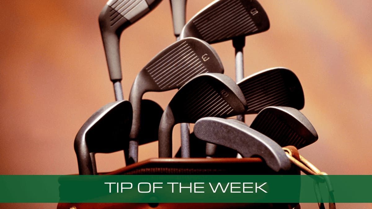 a pile of golf clubs sitting on top of a bag