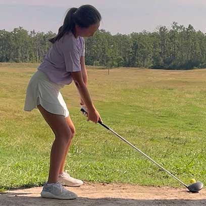 a girl is playing golf in the field