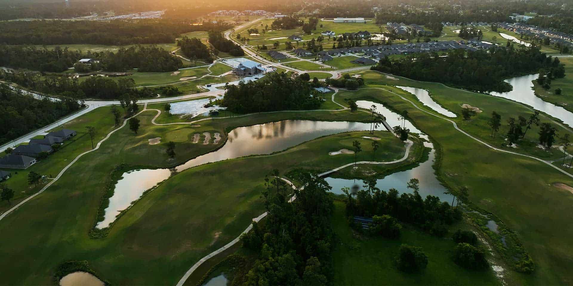 an aerial view of a golf course and water