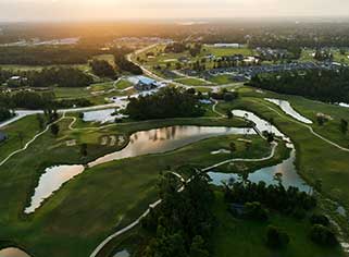 an aerial view of a golf course at sunset