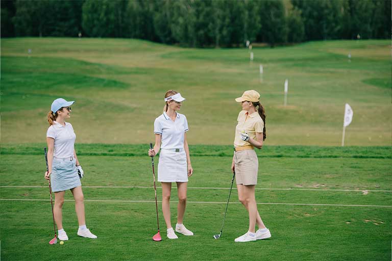 three women are standing on the golf course