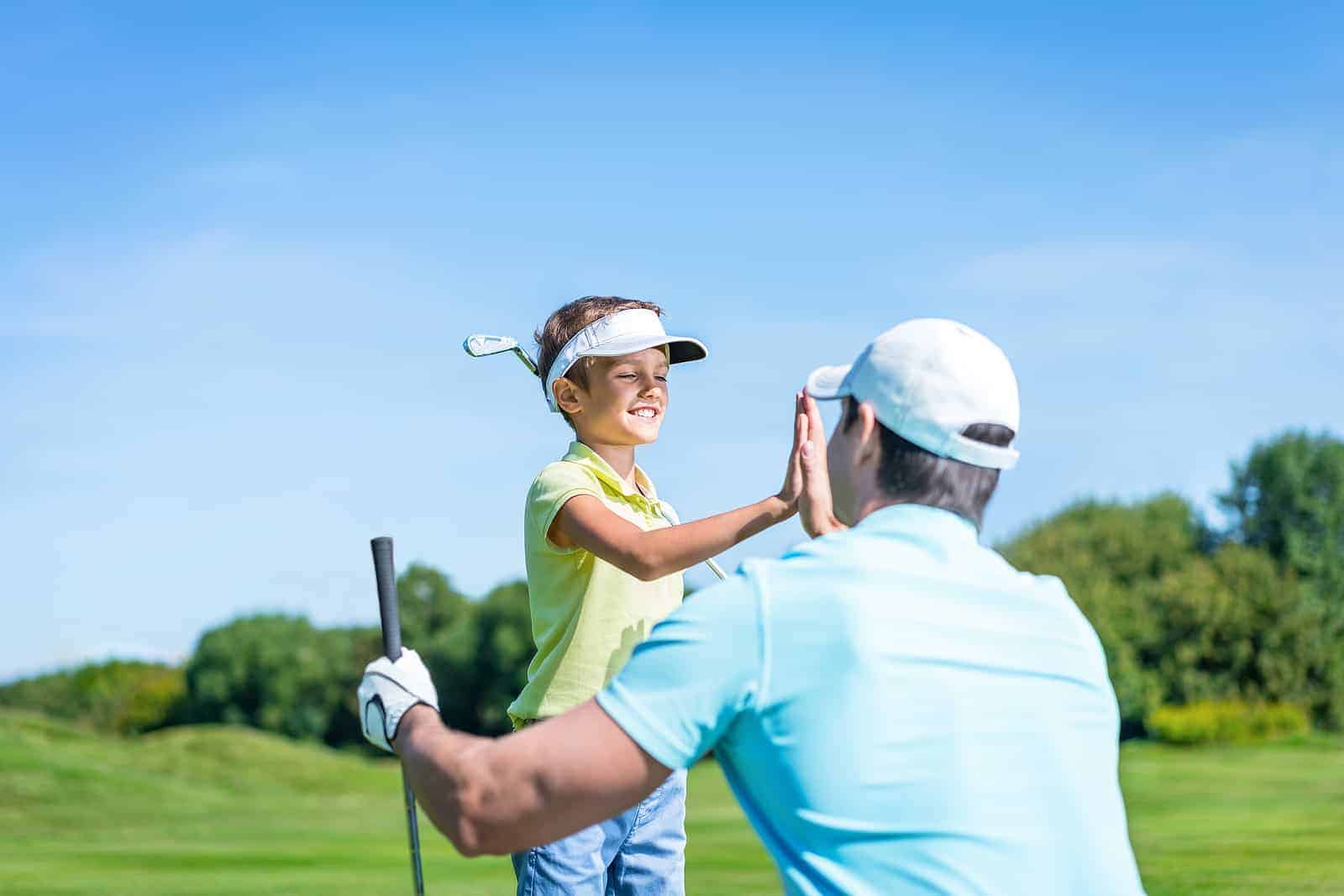 a man and a little girl playing golf